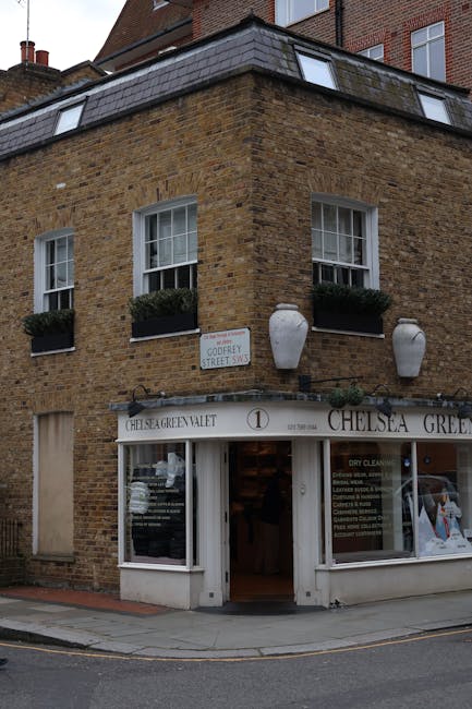 The image shows the exterior of a traditional brick terraced house on Kings Road in Chelsea, featuring a grey tiled pitched roof with chimney stacks and black guttering along the roofline. A small, we